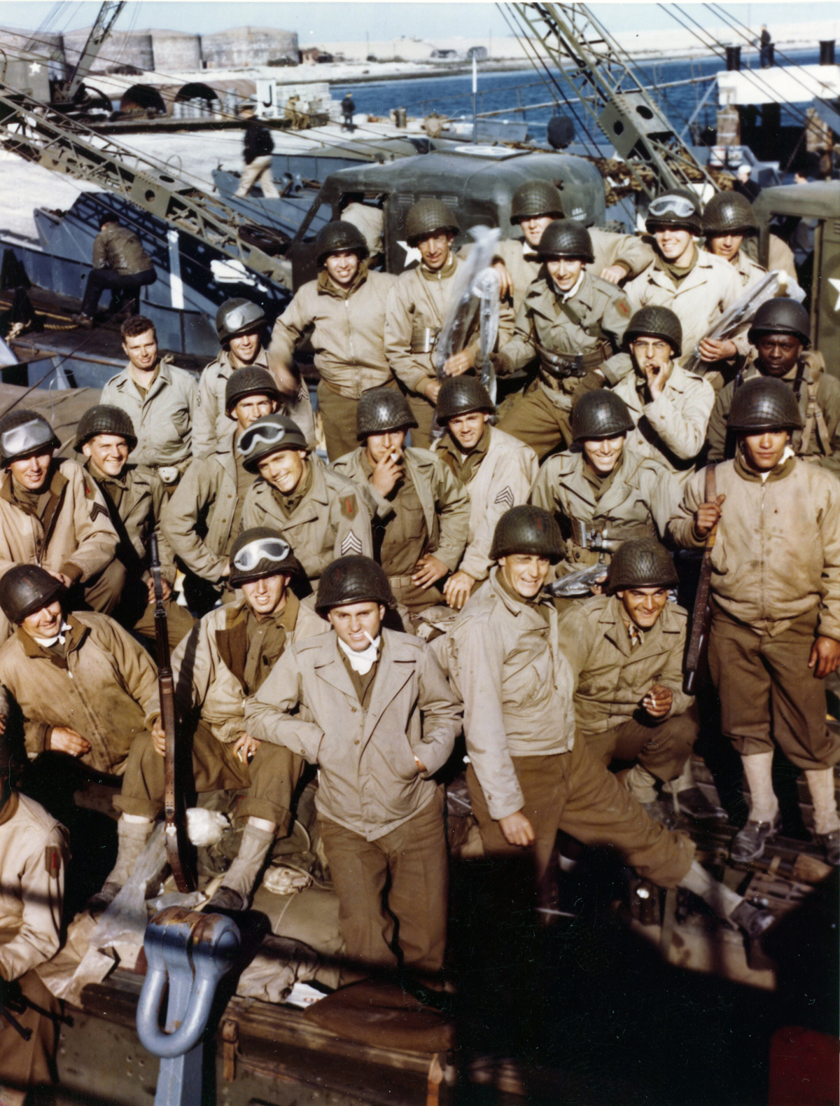 1st Infantry Division soldiers, some with their rifles already wrapped in waterproofing cellophane, pose for a photo aboard ship before leaving England for the D-Day invasion. 1st Infantry Division soldiers, some with their rifles already wrapped in waterproofing cellophane, pose for a photo aboard ship before leaving England for the D-Day invasion.